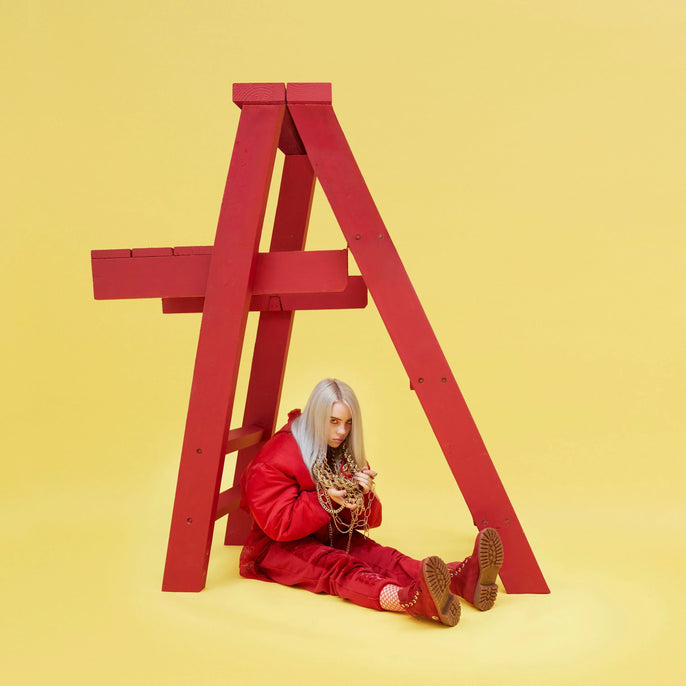 Person with silver hair in red outfit sitting under red structure on yellow background, album cover