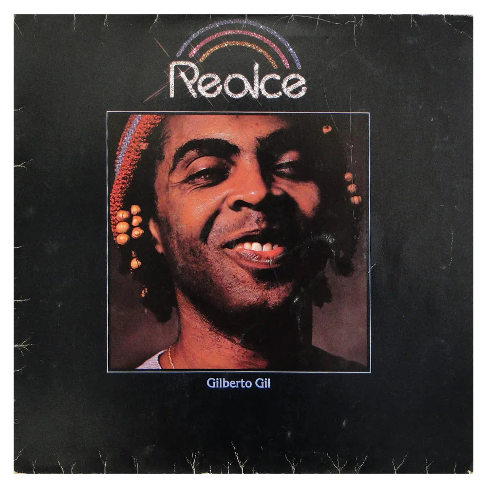 Album cover for "Realce" by Gilberto Gil, featuring a close-up photo of the artist smiling, with "Realce" and a rainbow graphic above his head.