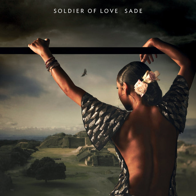 Sade Soldier of Love album cover featuring a woman with flowers in her hair and open-back dress overlooking ancient ruins.