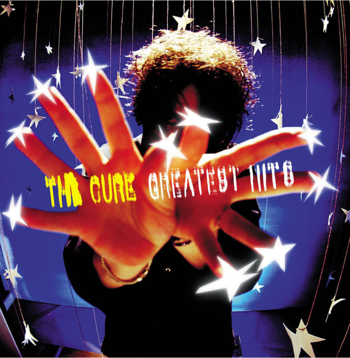 The Cure Greatest Hits album cover with outstretched hands, stars, and bold album title text.