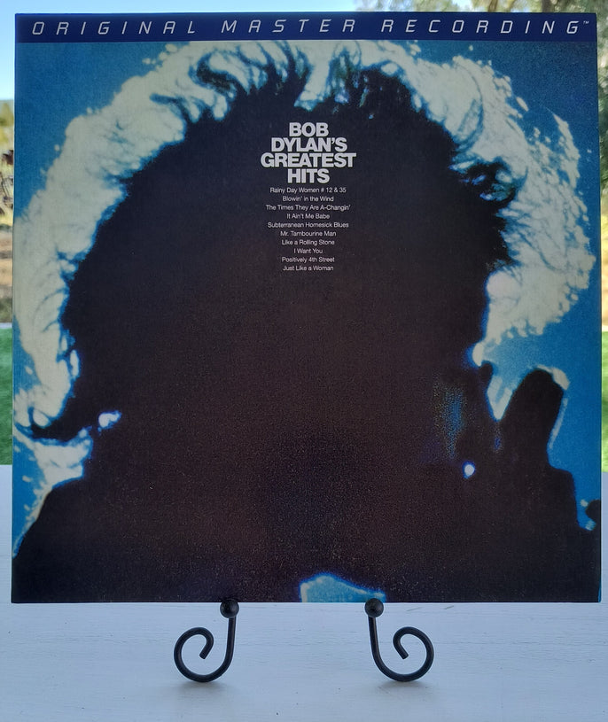 Bob Dylan's Greatest Hits vinyl record with blue silhouette cover, displayed on a stand