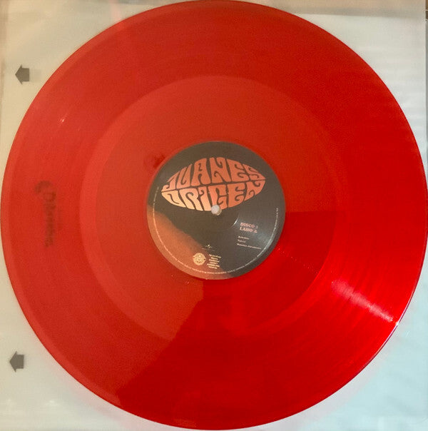 Red translucent vinyl record with psychedelic label design on a turntable