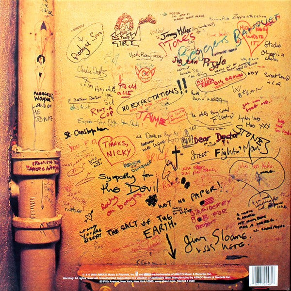 Yellow wall covered in colorful handwritten graffiti and song titles, vintage vinyl album art.