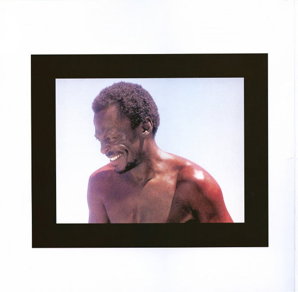 Smiling man with bare shoulders against a light background, featured on a vinyl record cover.