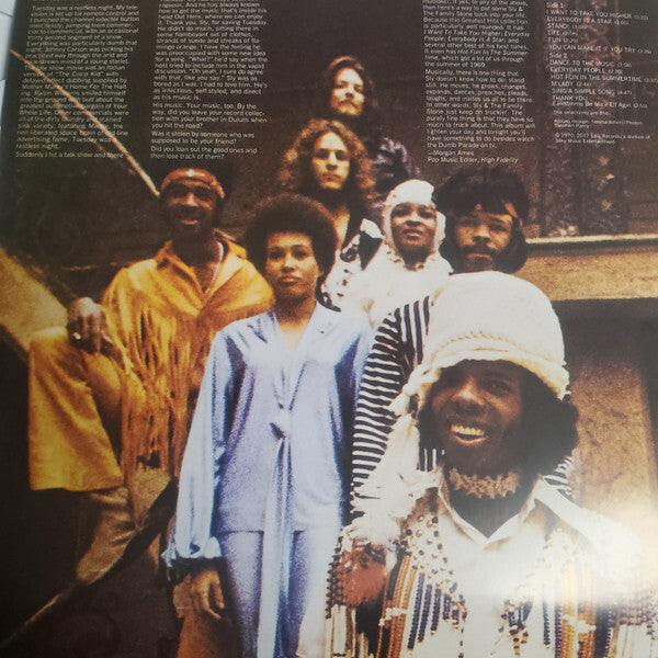 Vintage soul and funk band in colorful outfits posing on outdoor stairs, vinyl record cover style.