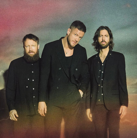 Three men in black suits standing together with a soft gradient background, music band photo