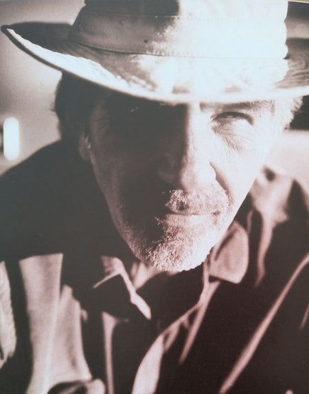 Close-up sepia portrait of an older man in a hat, dramatic lighting, vintage style