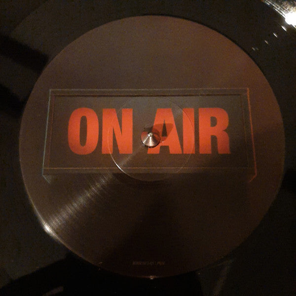 Vinyl record with 'ON AIR' label in bold red letters, close-up view