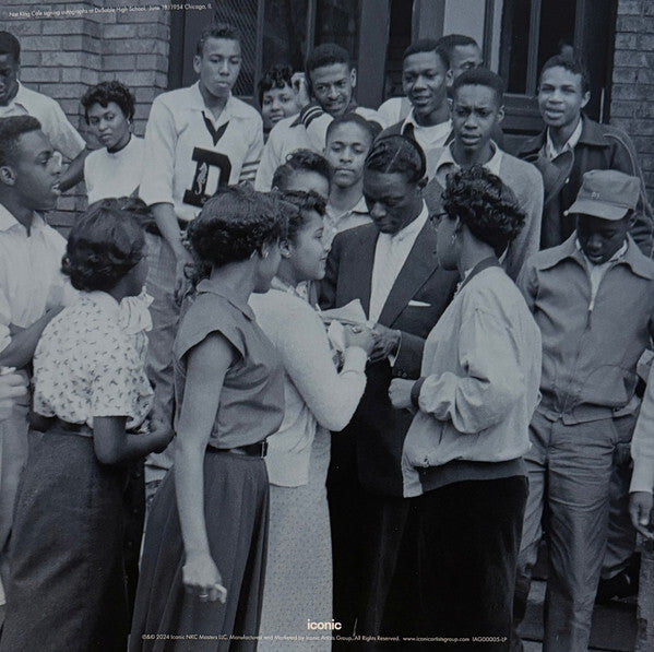 Vintage photo of a man signing autographs for a group of young people outside a building