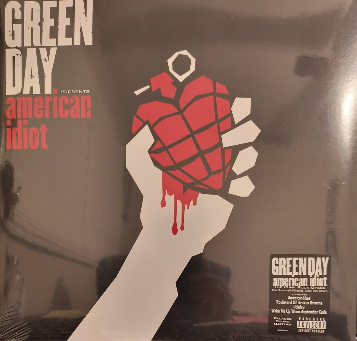 Green Day American Idiot vinyl album cover with bleeding heart grenade graphic on black background.