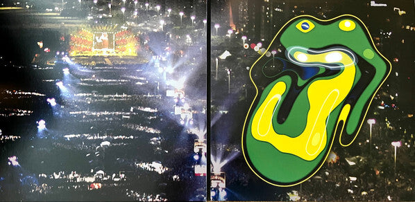 Large outdoor concert crowd at night with colorful abstract tongue and lips vinyl album art