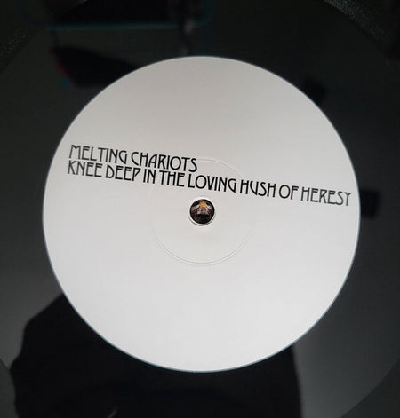Close-up of Melting Chariots vinyl record label, minimalist white design, music collectors