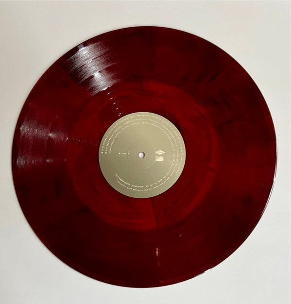 Red marbled vinyl record with beige center label on white background