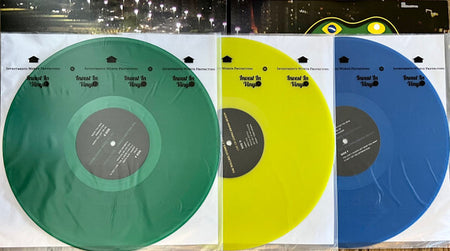 Green, yellow, and blue colored vinyl records in clear sleeves, music collectibles display