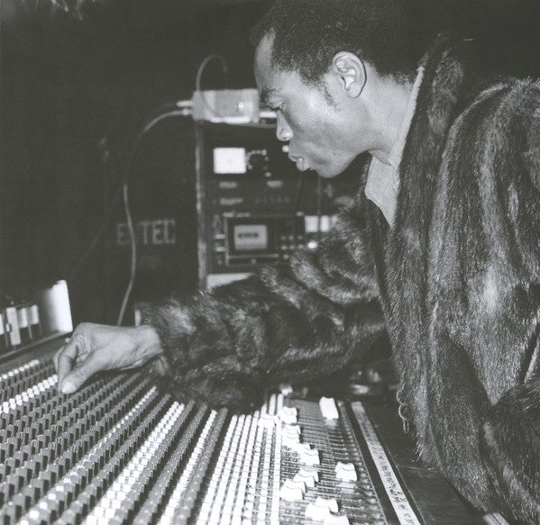 Black and white photo of man using audio mixing console in recording studio, classic music production scene