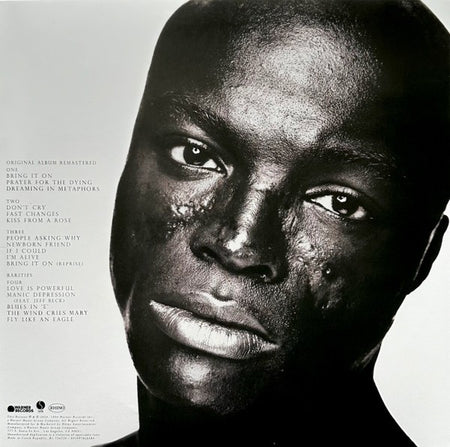 Close-up of a vinyl album cover featuring a man’s face with tracklist on the left side