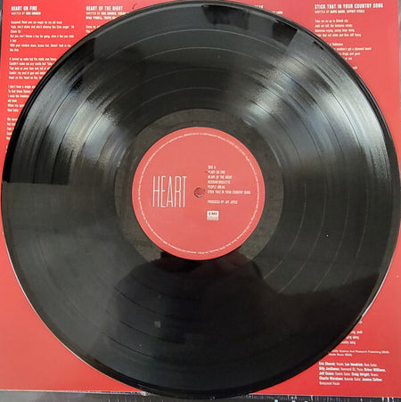 Heart vinyl record on red background with tracklist and lyrics visible, classic rock album.