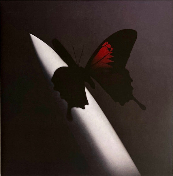 Vinyl record cover with a dark butterfly and red markings perched on a knife blade