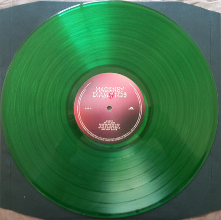 Green translucent Hackney Diamonds vinyl record displayed on dark sleeve