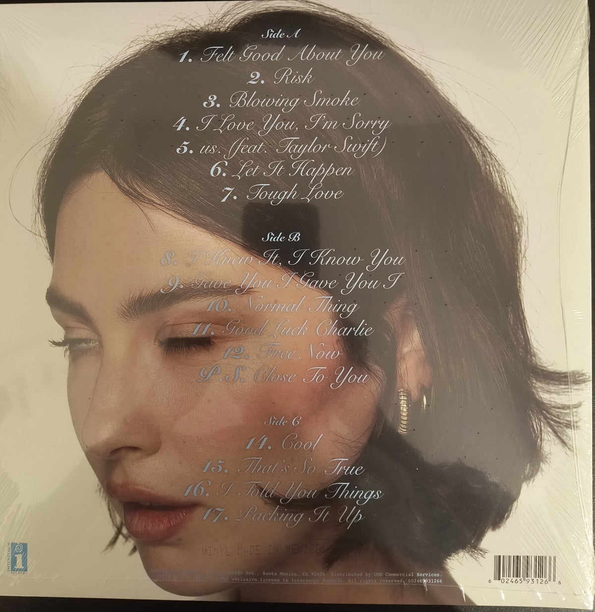 Vinyl record album back cover with woman's face, tracklist, and soft neutral background.