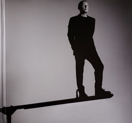 Black and white photo of a man in a suit balancing on a narrow beam, minimalistic style.