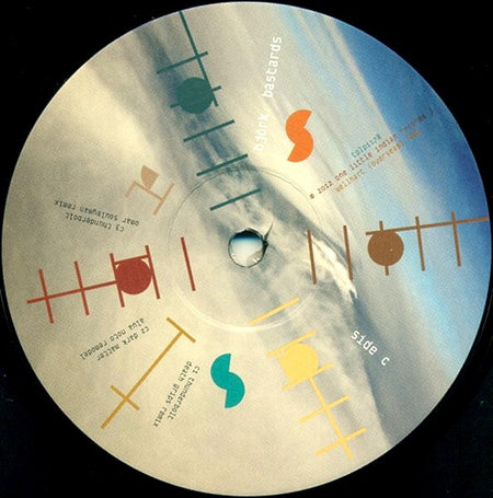 Close-up of a vinyl record with abstract colored graphics and tracklist text on the label.