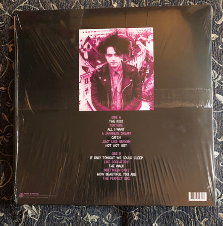 Vinyl record back cover featuring pink-toned portrait, tracklist, shrink wrap, dark background