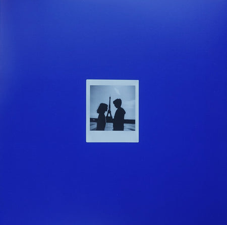 Vinyl record cover with a blue background and a polaroid of two people in silhouette.