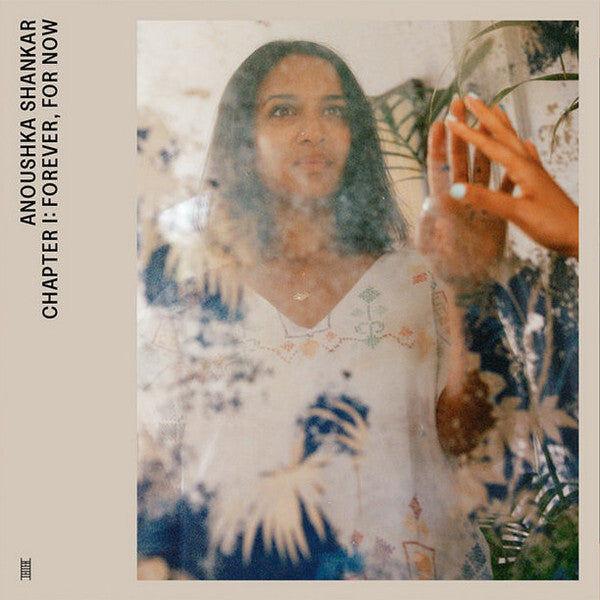 Vinyl record cover featuring a woman in a white dress reflected in a floral-patterned mirror with plants.