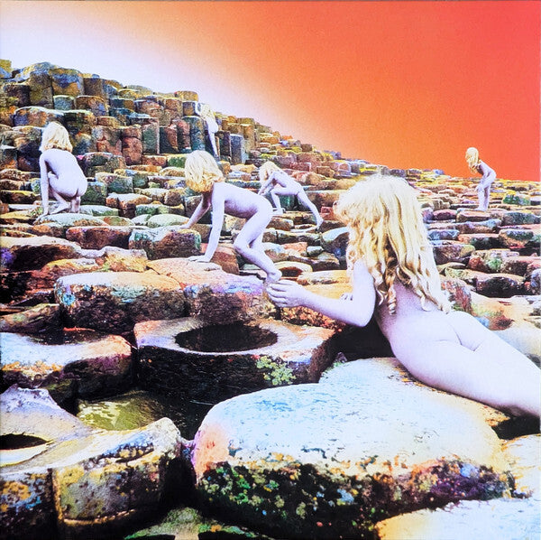 Surreal album cover with children on rocky basalt columns under a vivid orange sky
