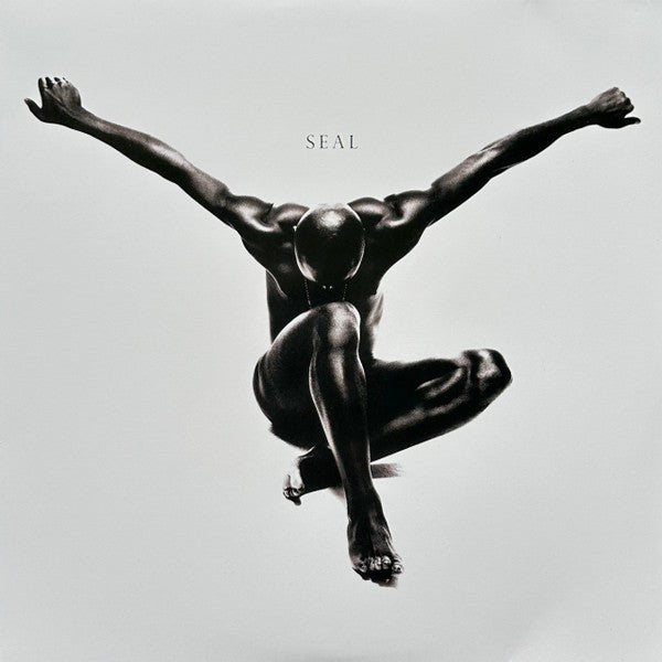 Monochrome album cover featuring a crouched man with arms extended, 'Seal' text above.