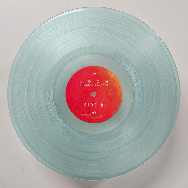 Clear vinyl record of Imagine Dragons' LOOM, Side B, with red and orange label on white background