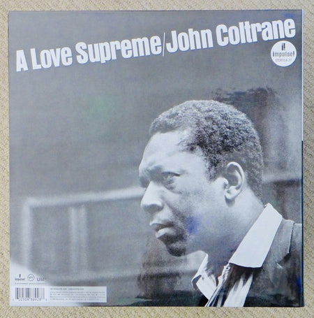 A Love Supreme by John Coltrane vinyl record album cover featuring a black and white portrait.