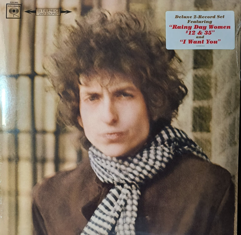 Vintage vinyl record cover featuring a curly-haired man in a checkered scarf, muted background.