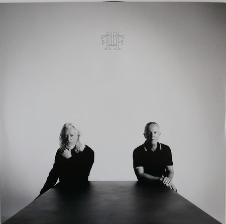 Black and white vinyl album cover with two men sitting at a table, minimalist design, music record